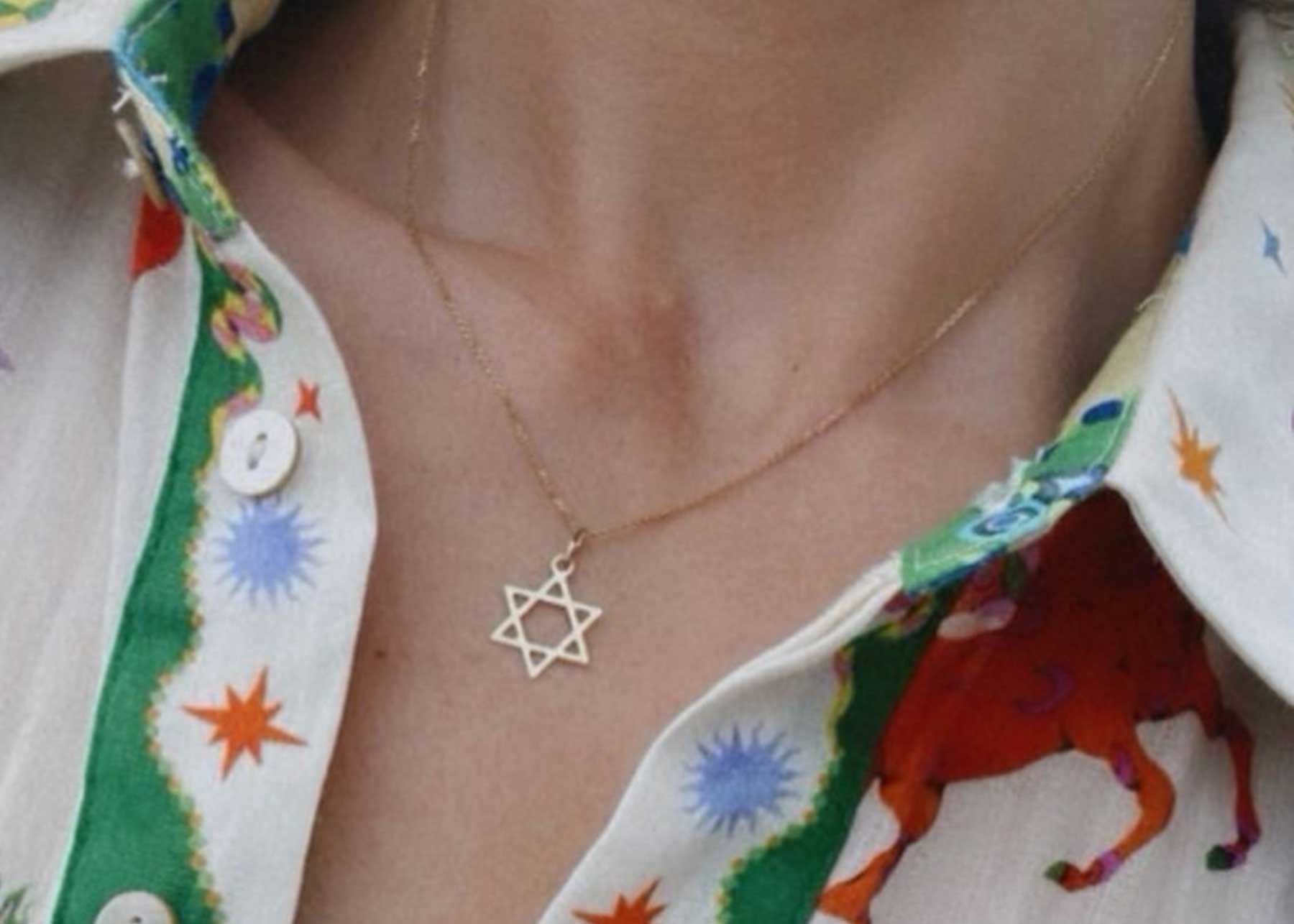 Gold Star of David necklace worn with a printed shirt